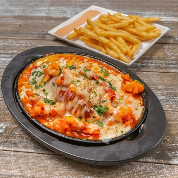 Mofongo Restaurant's cheesy Caribbean shrimp and lobster dish with a side of golden french fries.